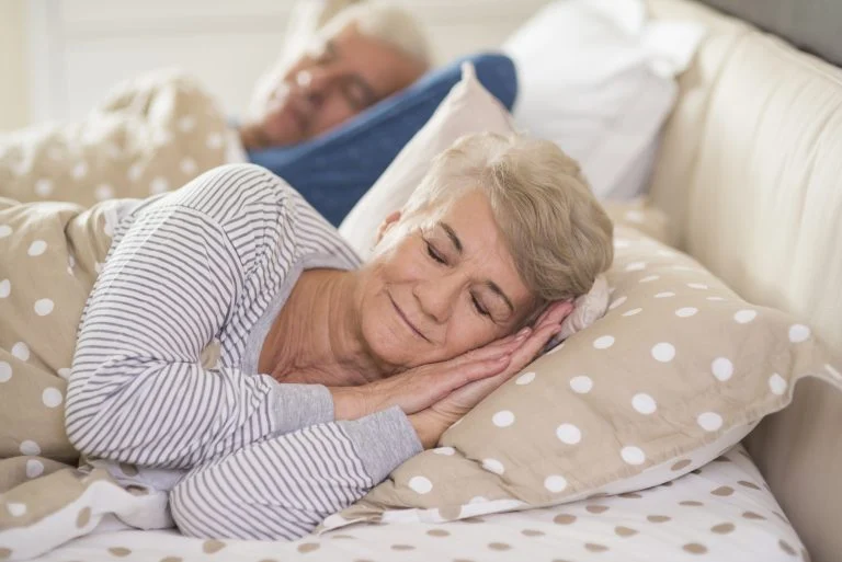 Couple sleeping comfortably in bed